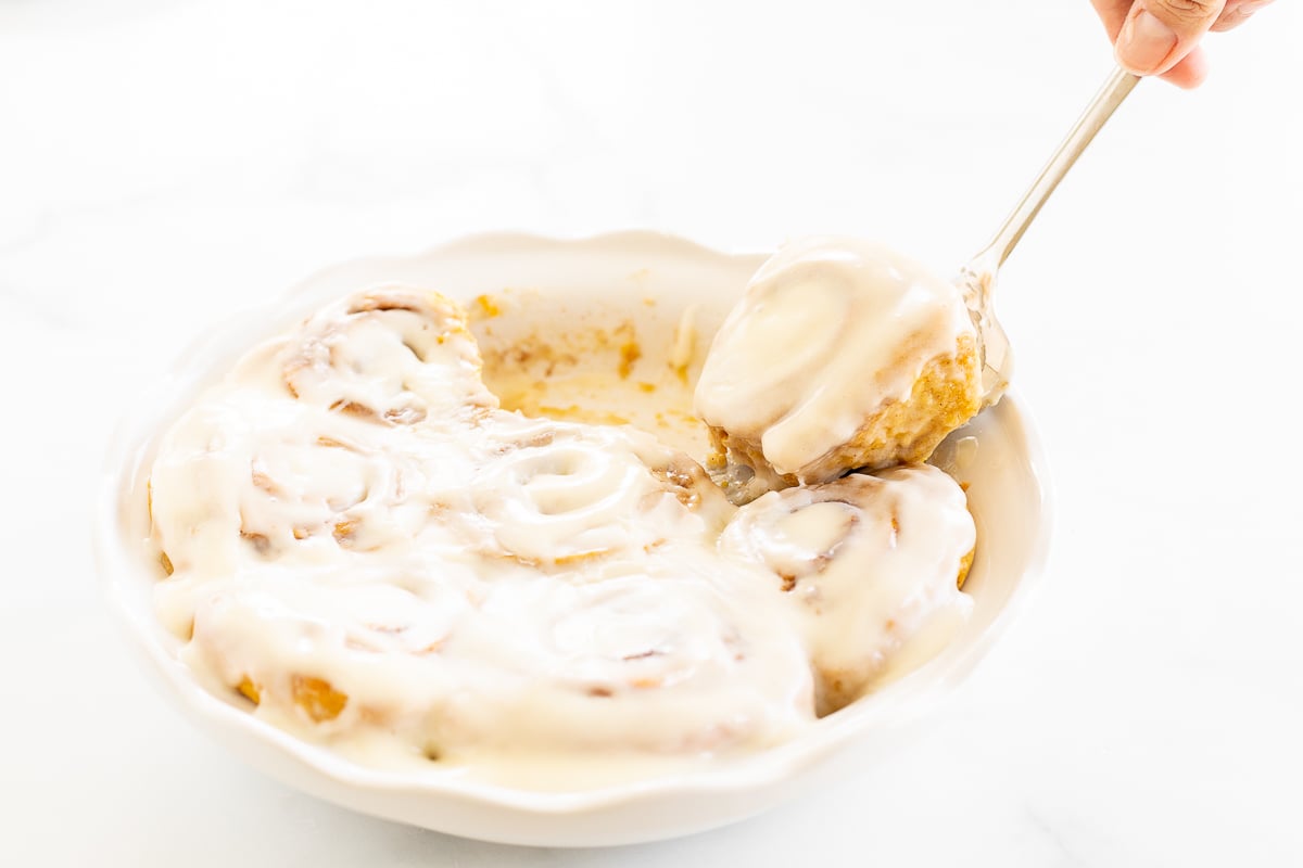 A person is holding a bowl of Pumpkin Cinnamon Rolls.