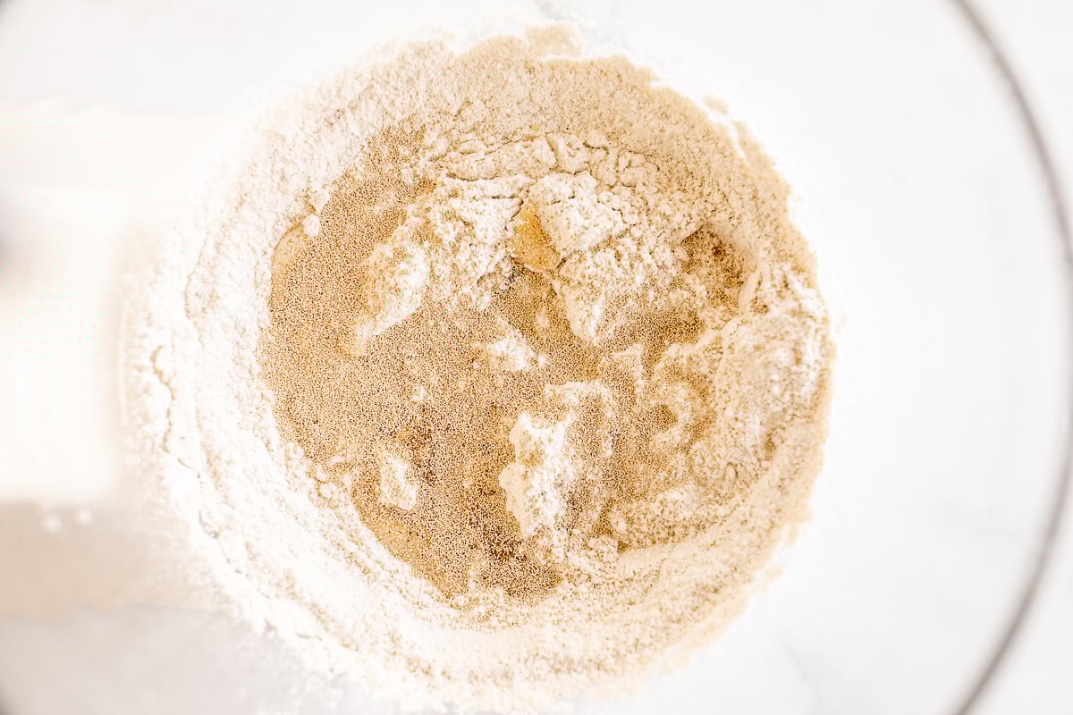 A close up of flour in a mixing bowl, ready to be used for making Pumpkin Cinnamon Rolls.