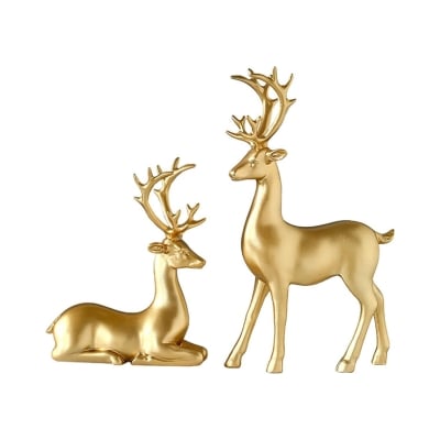 Two gold deer figurines, perfect for Christmas decorations, on a bright white background.