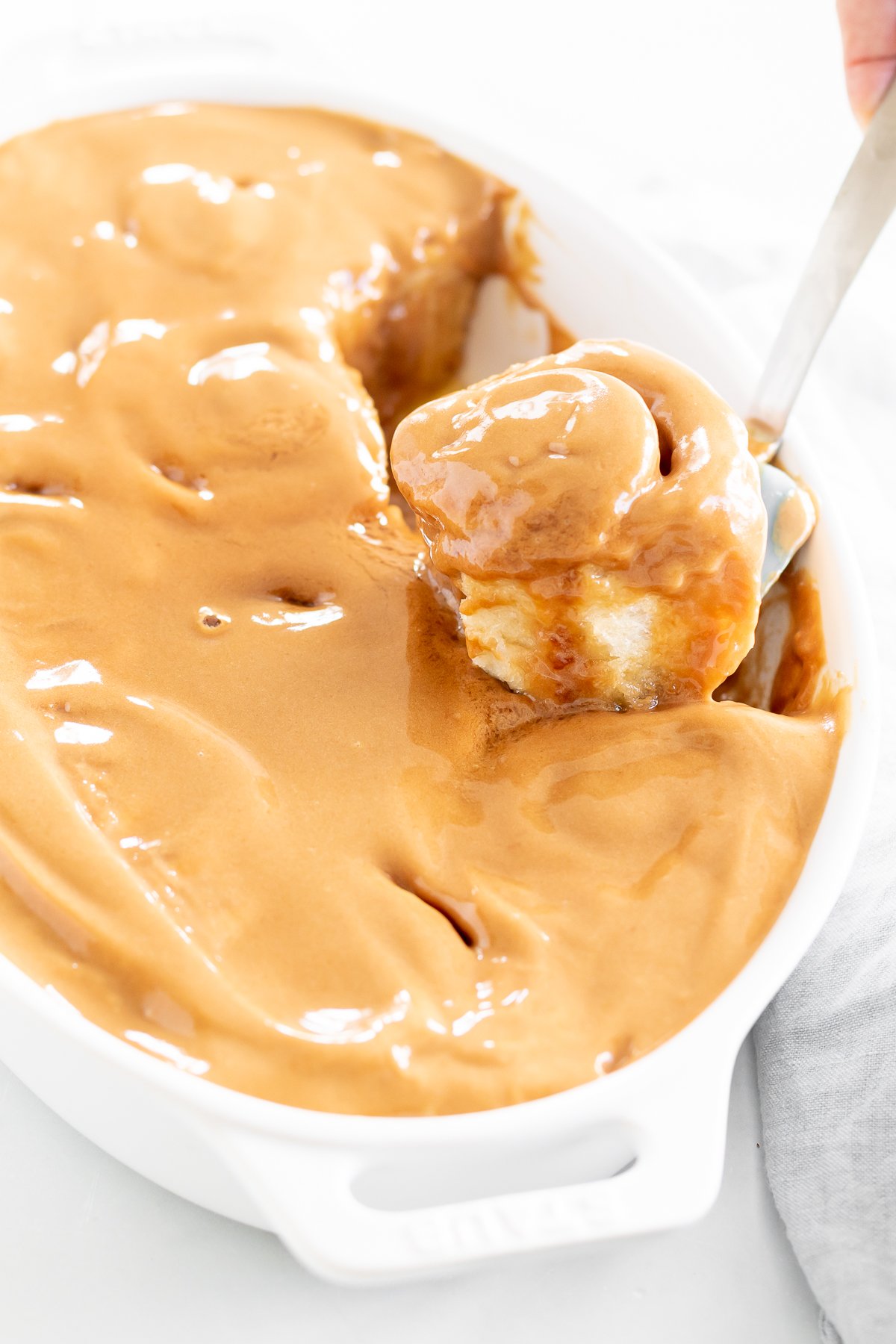 A person spreading Cookie Butter on a white dish.