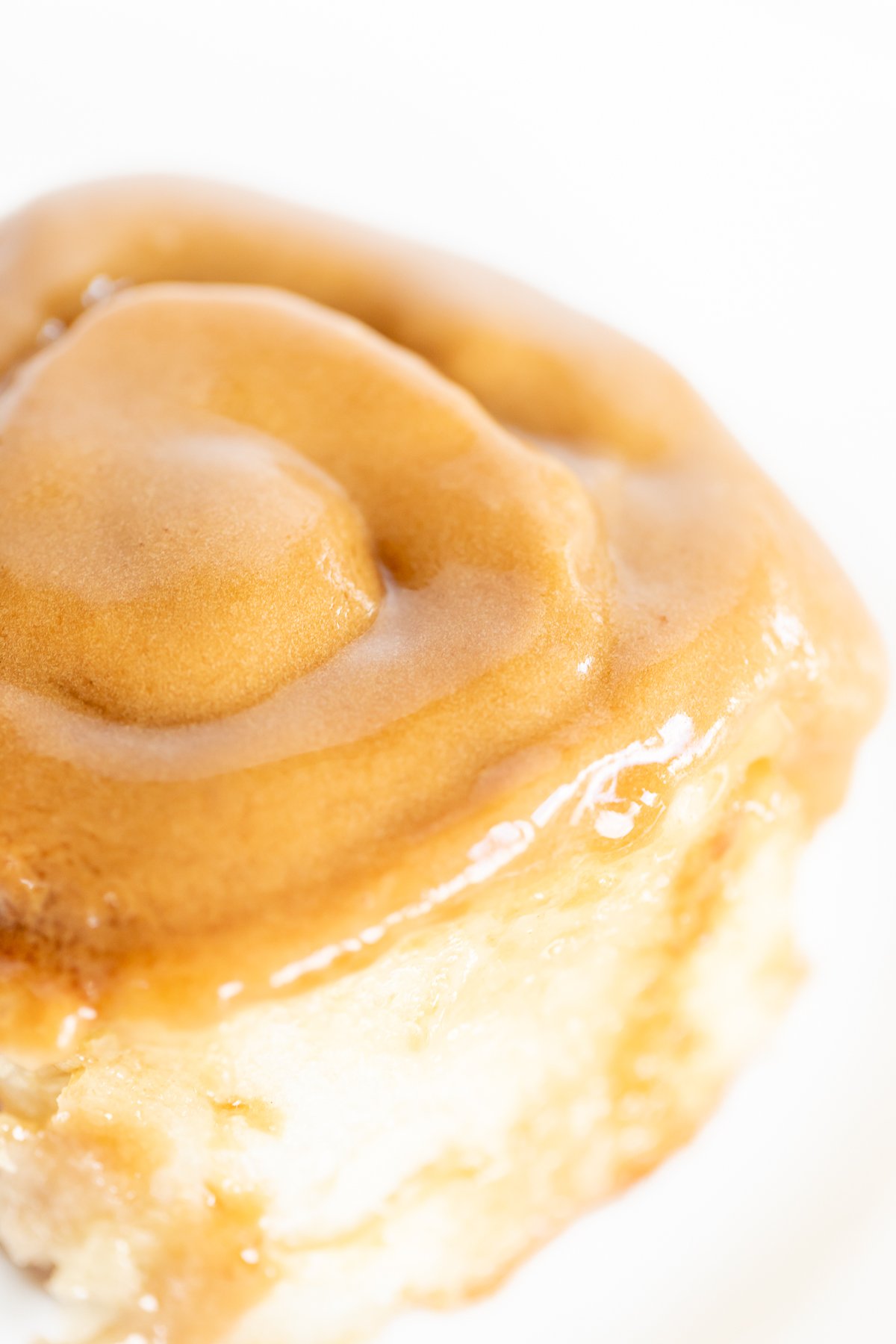 A Cookie Butter Cinnamon Roll on a plate, accompanied by a fork.