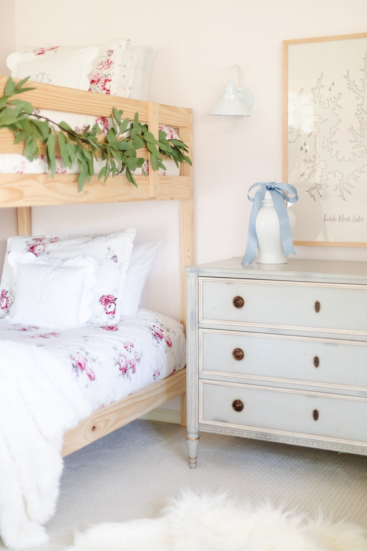 A girl's bedroom with bunk beds and a dresser.