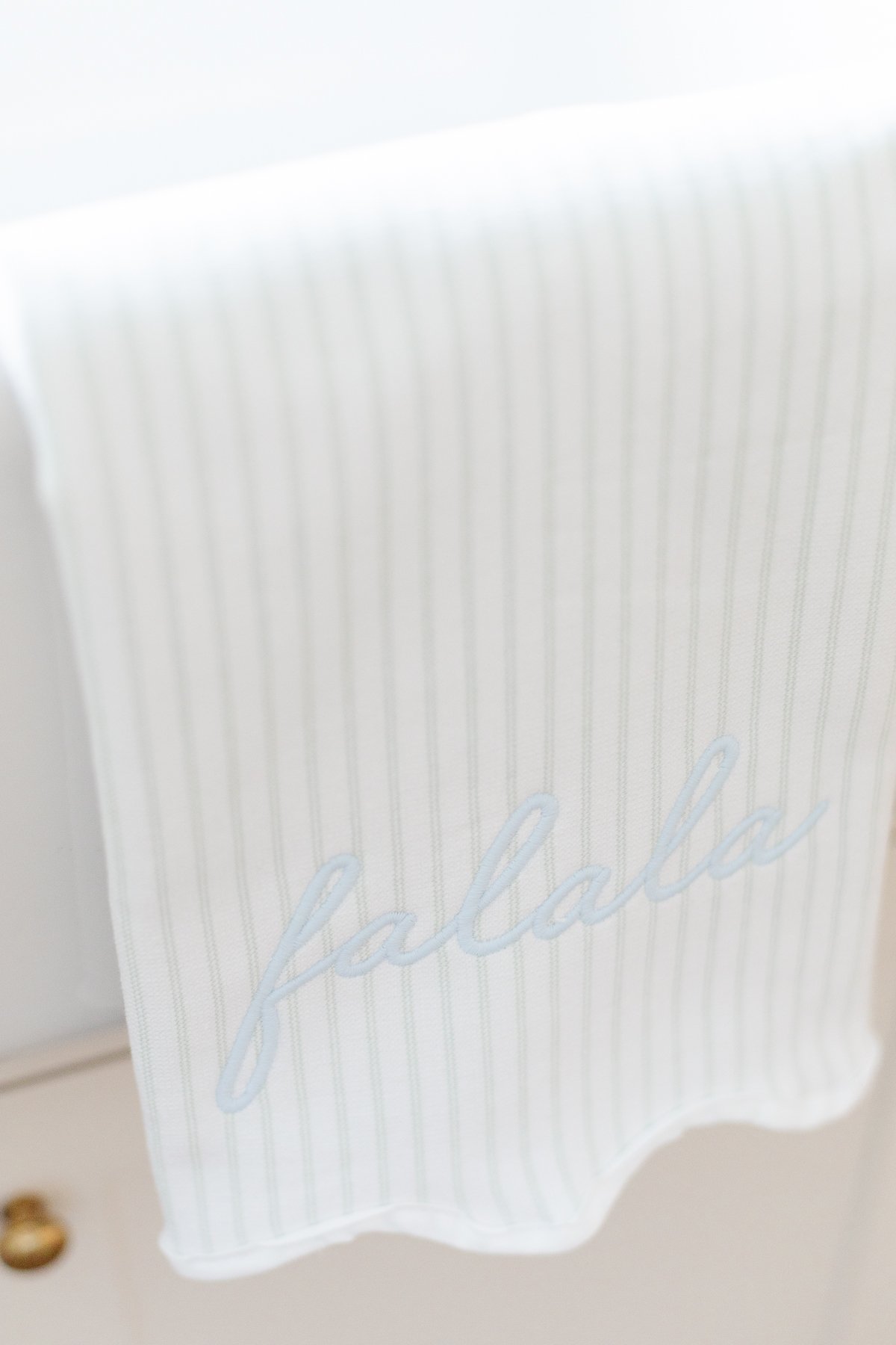 A faalis-themed kitchen gift, featuring a blue and white striped towel with the word faalis on it.