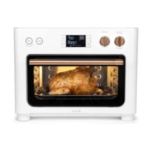 A whole chicken is roasting inside a white countertop oven, featuring a digital display and rotary knobs, seamlessly fitting into the kitchen counter organization of your space.