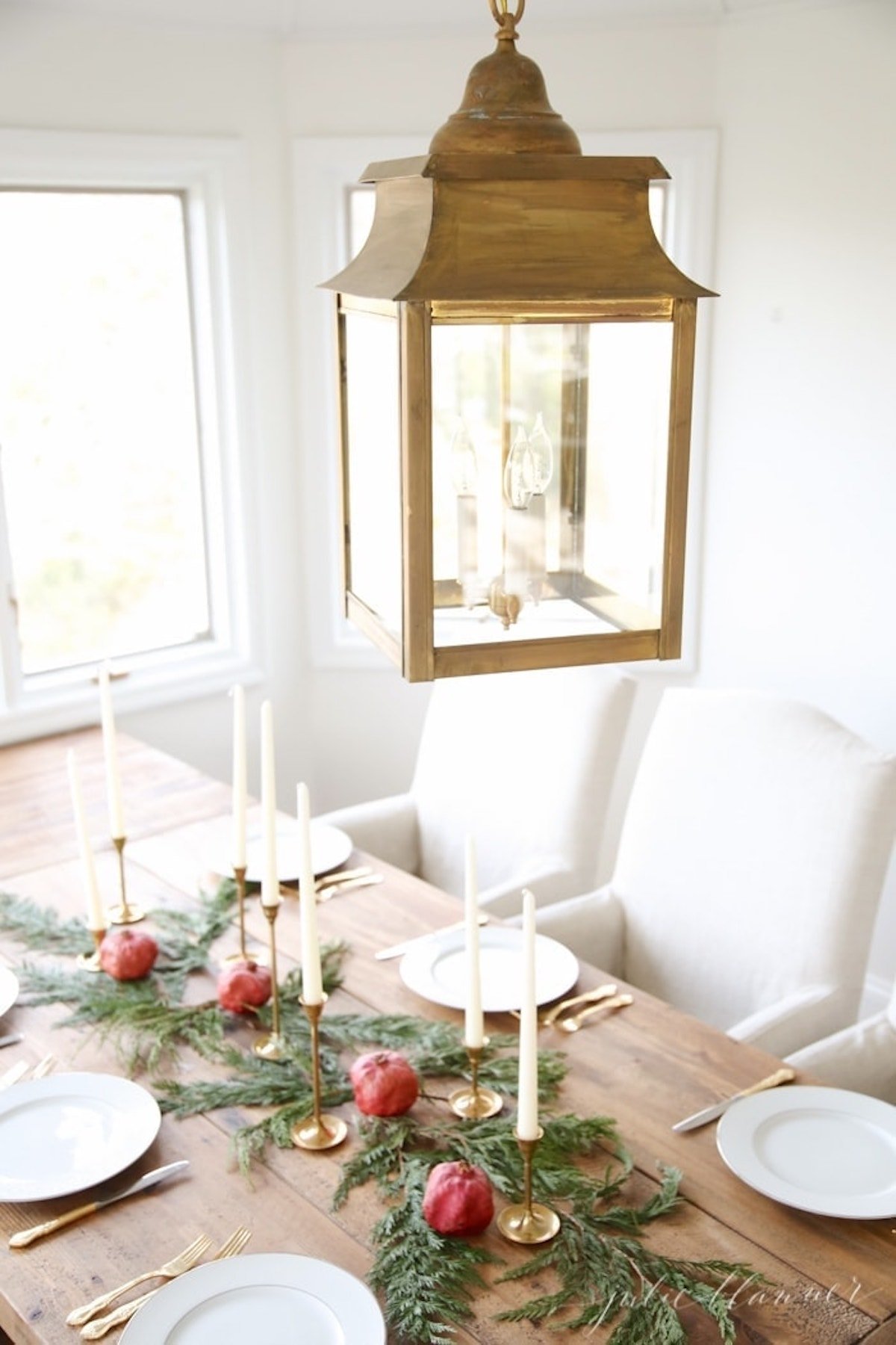 A stunning Christmas table setting adorned with a captivating candle centerpiece and lush greenery.