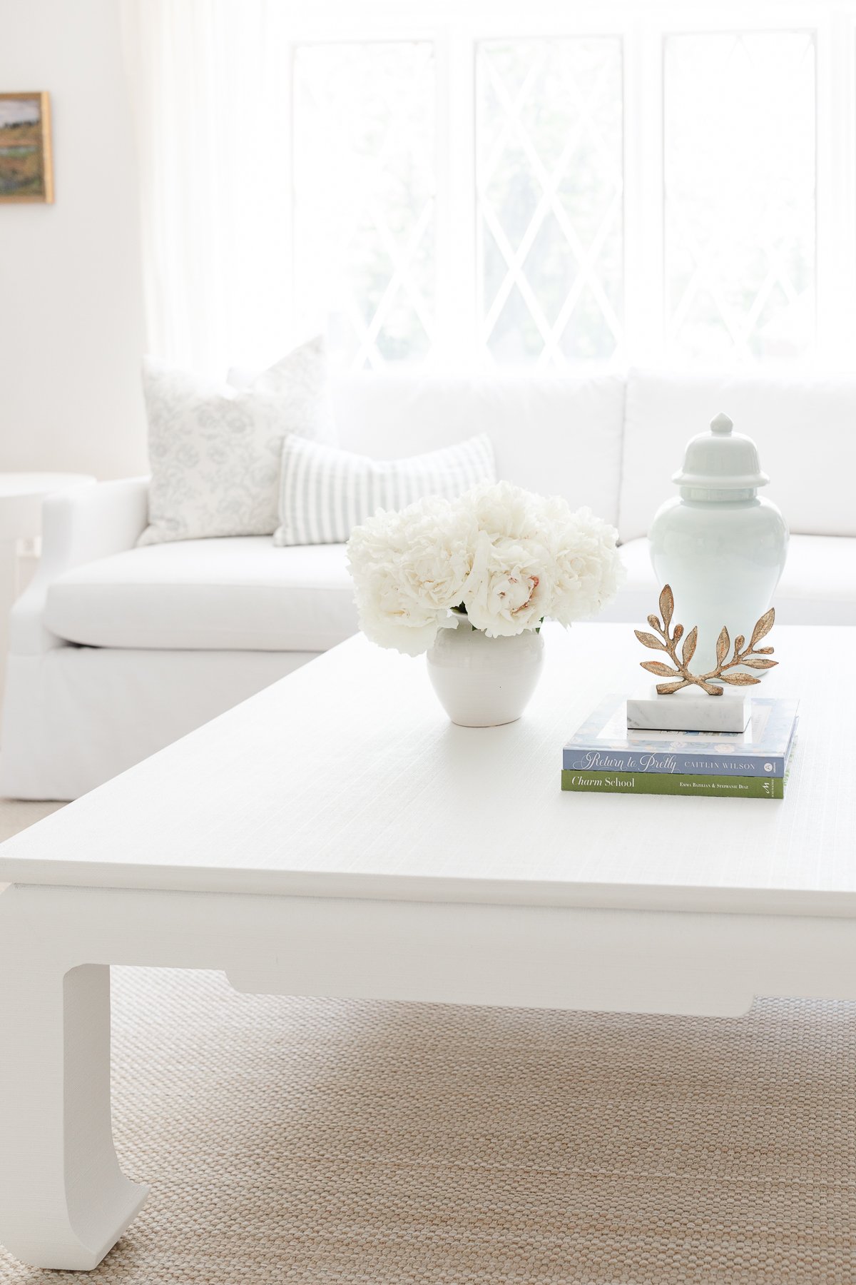 A white coffee table with ginger jars in a living room.