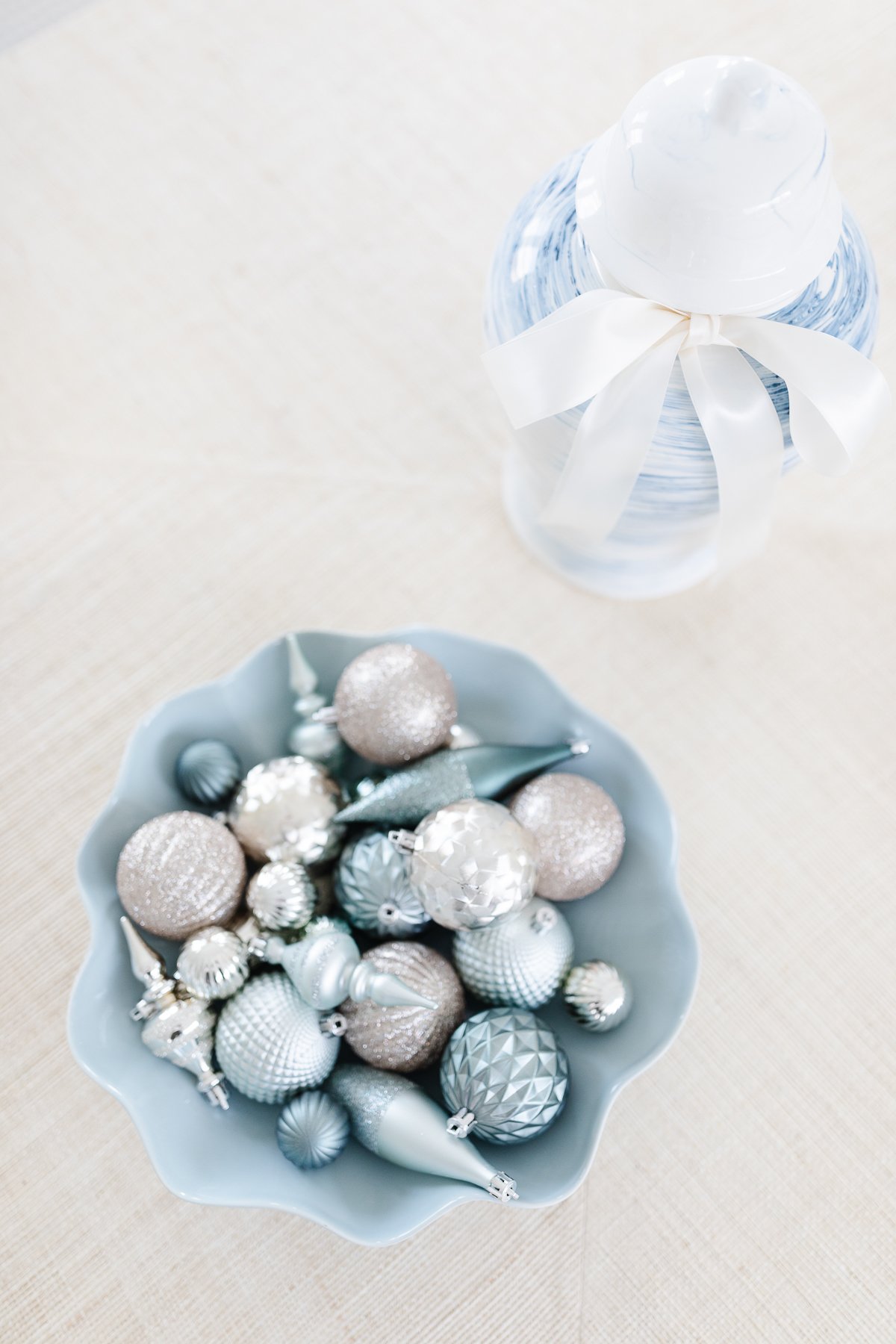 A blue bowl filled with ornaments on a table.