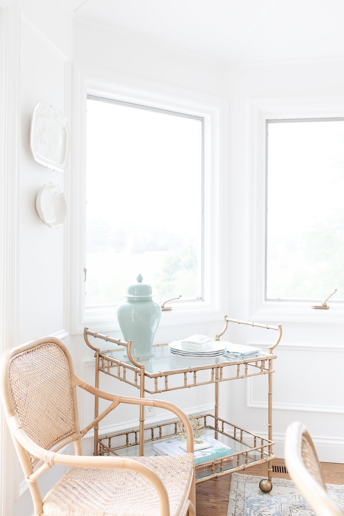 A white living room with a wicker chair and table.