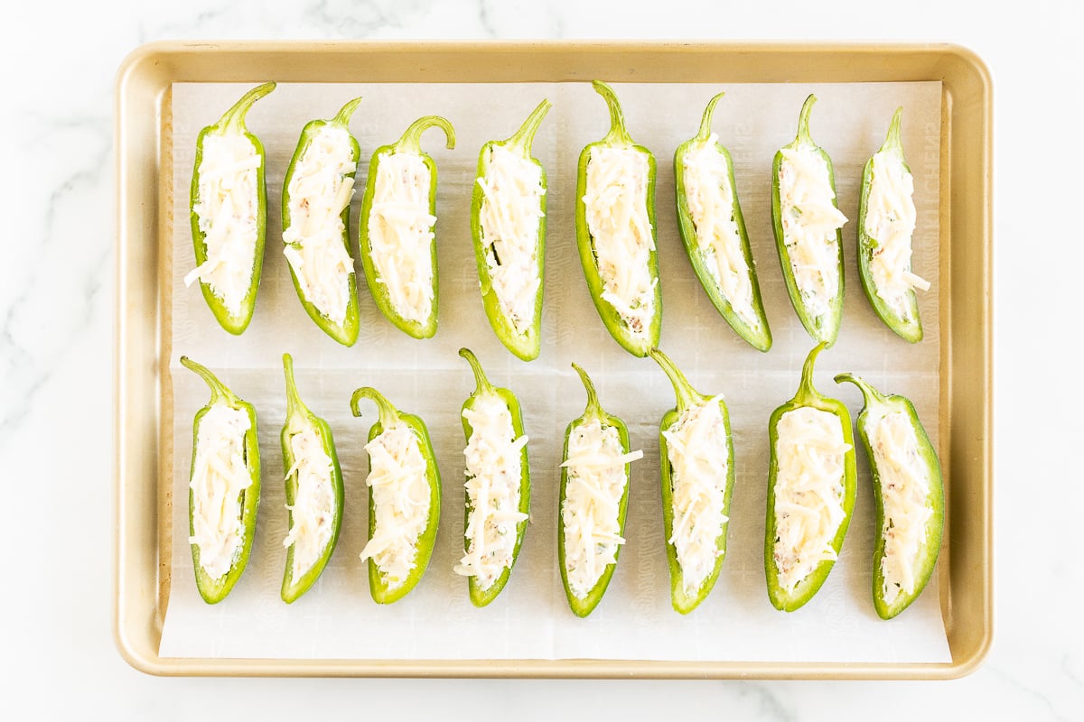Stuffed jalapeno peppers on a baking sheet.