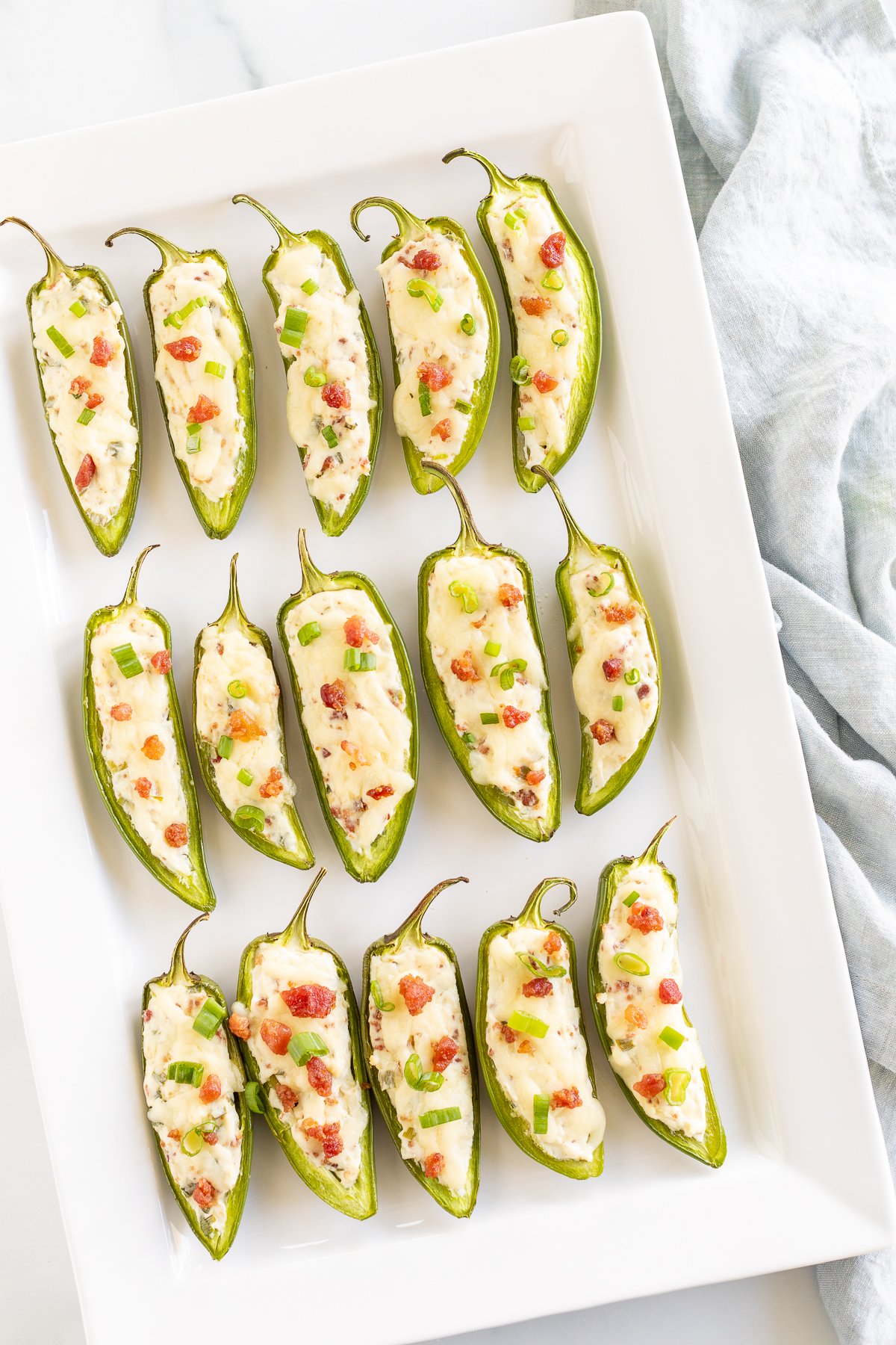 Stuffed jalapenos on a white plate.