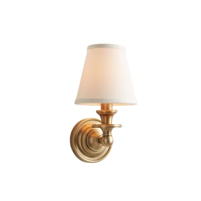A gold bathroom sconce with a white shade.
