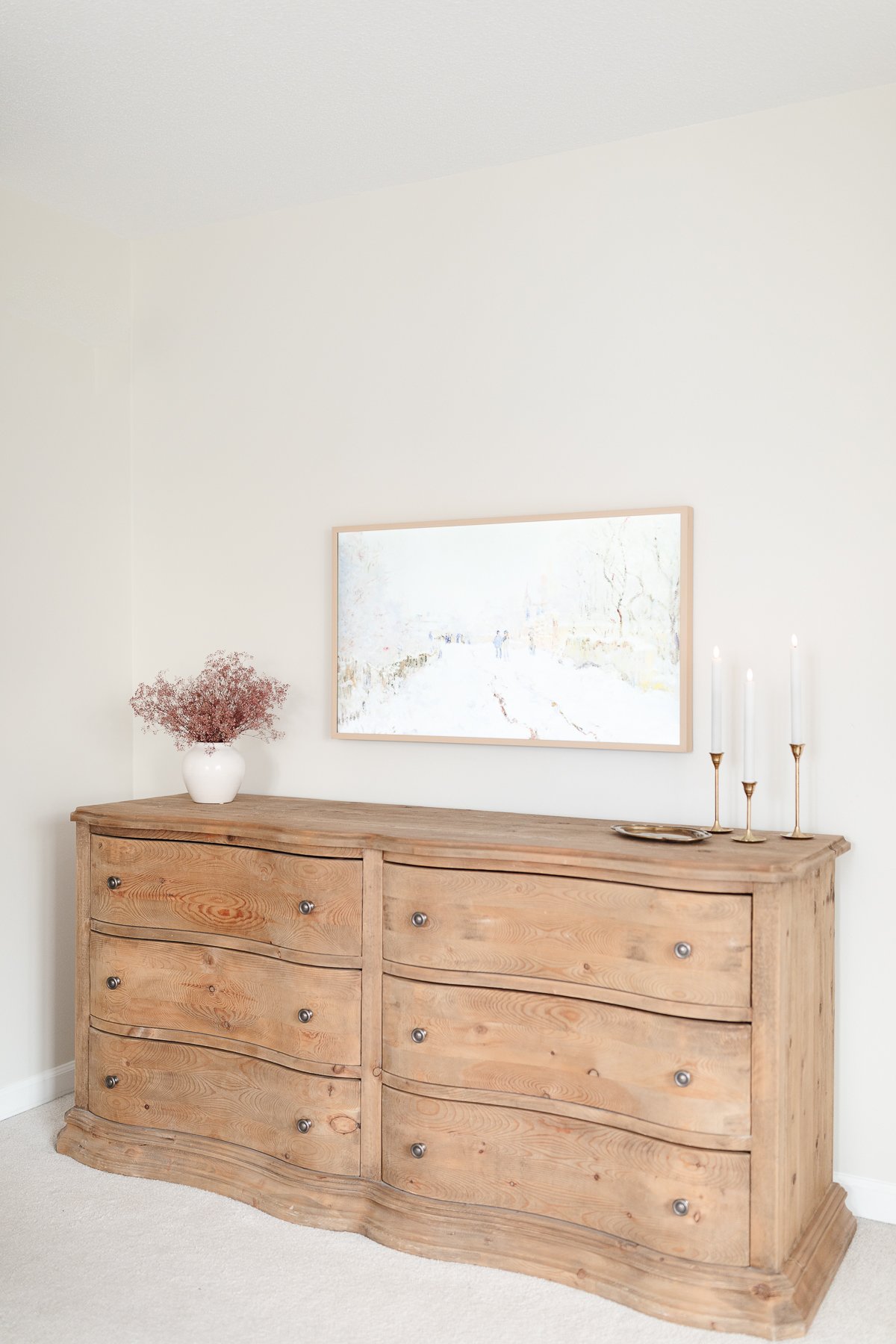 A curved wooden dresser in a room.