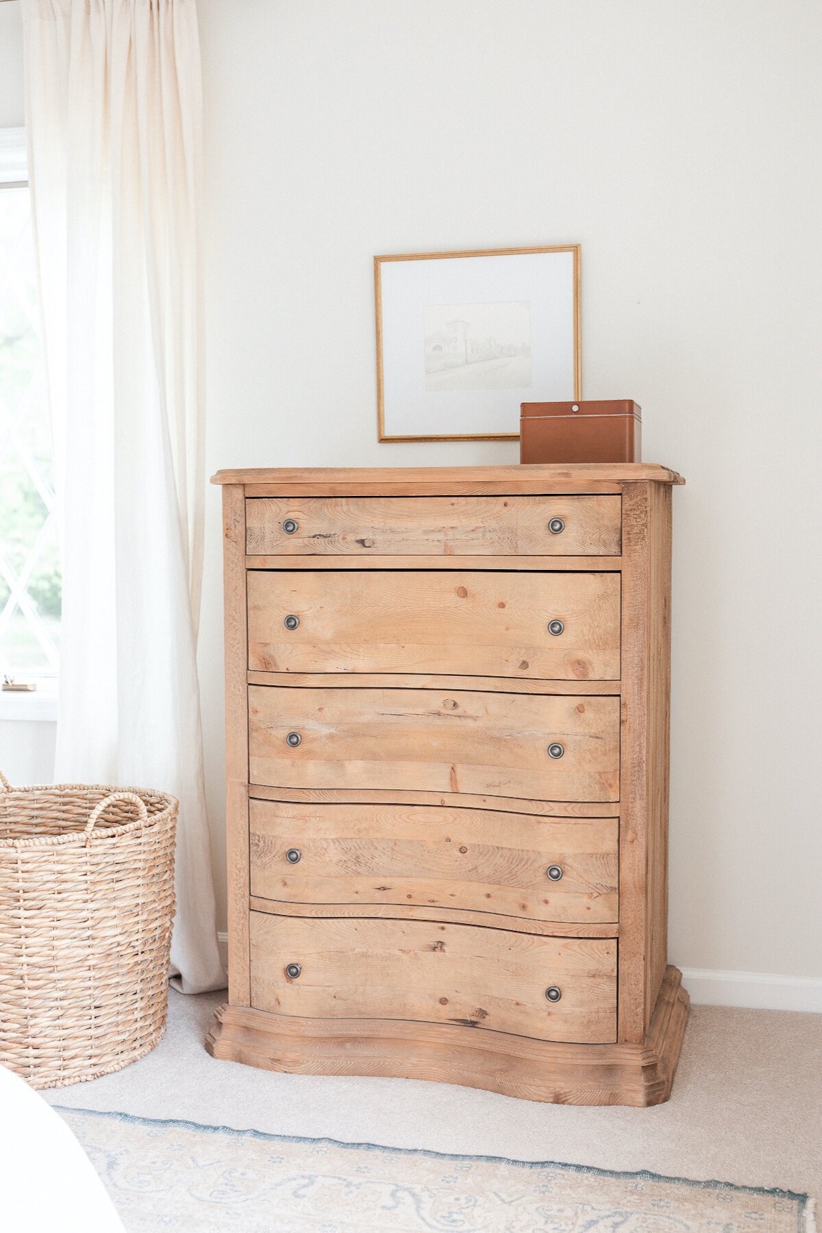 A curved wooden dresser in a bedroom.