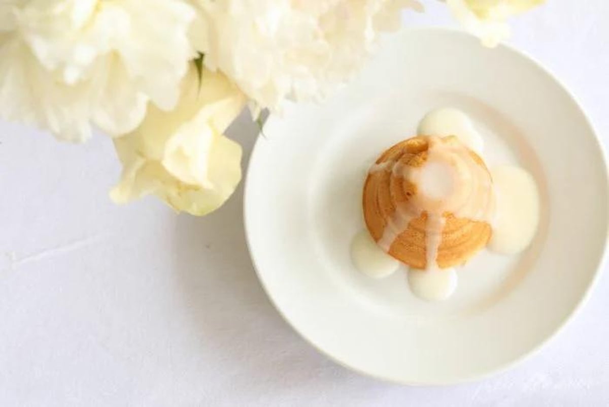 A white plate with a honey lemon cake on it.