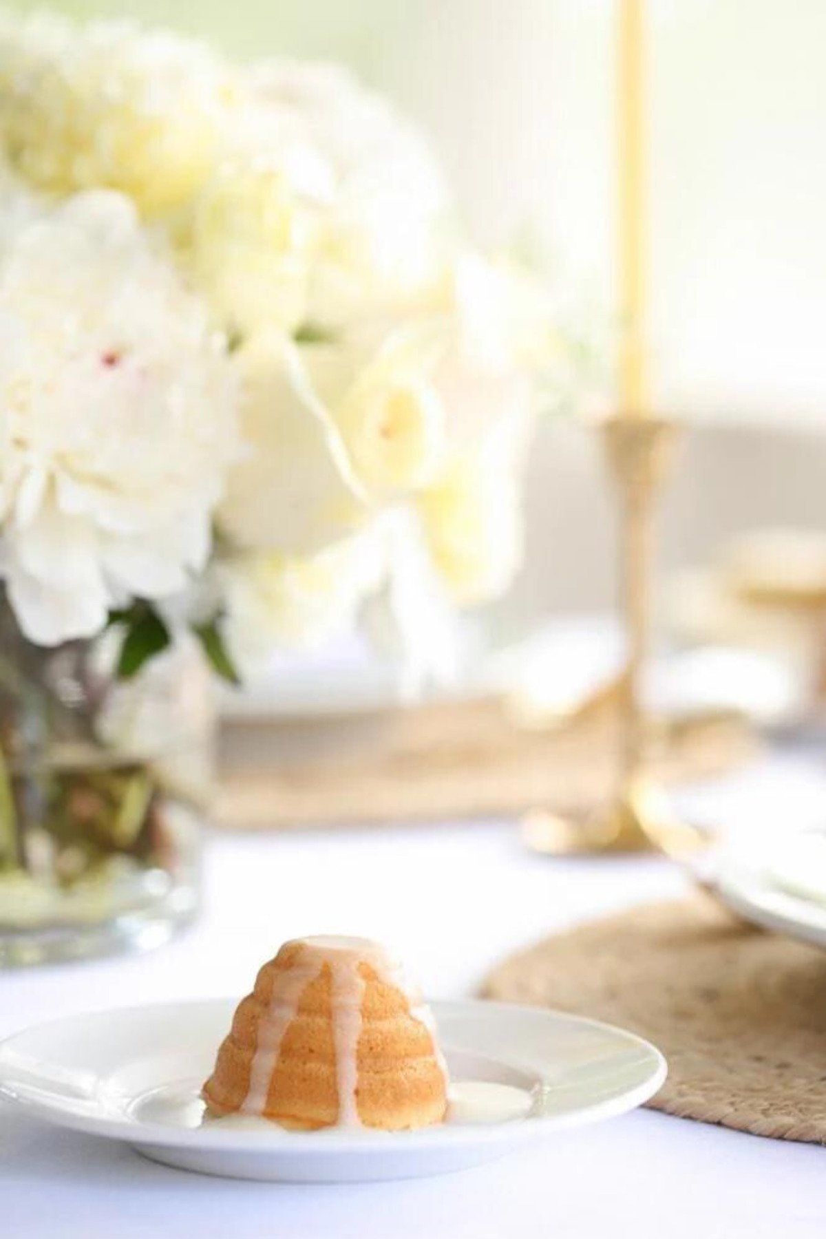 A plate with a honey lemon cake and flowers on it.