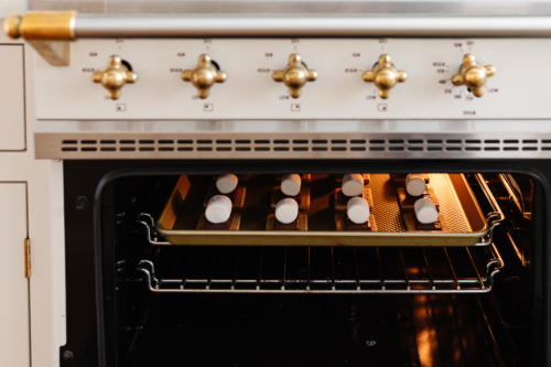 A white oven with a tray of cookies AND s'mores in it.