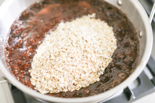 Oats and brown sugar are combined in a pot on a stove to create delicious preacher cookies or chocolate no bake cookies.