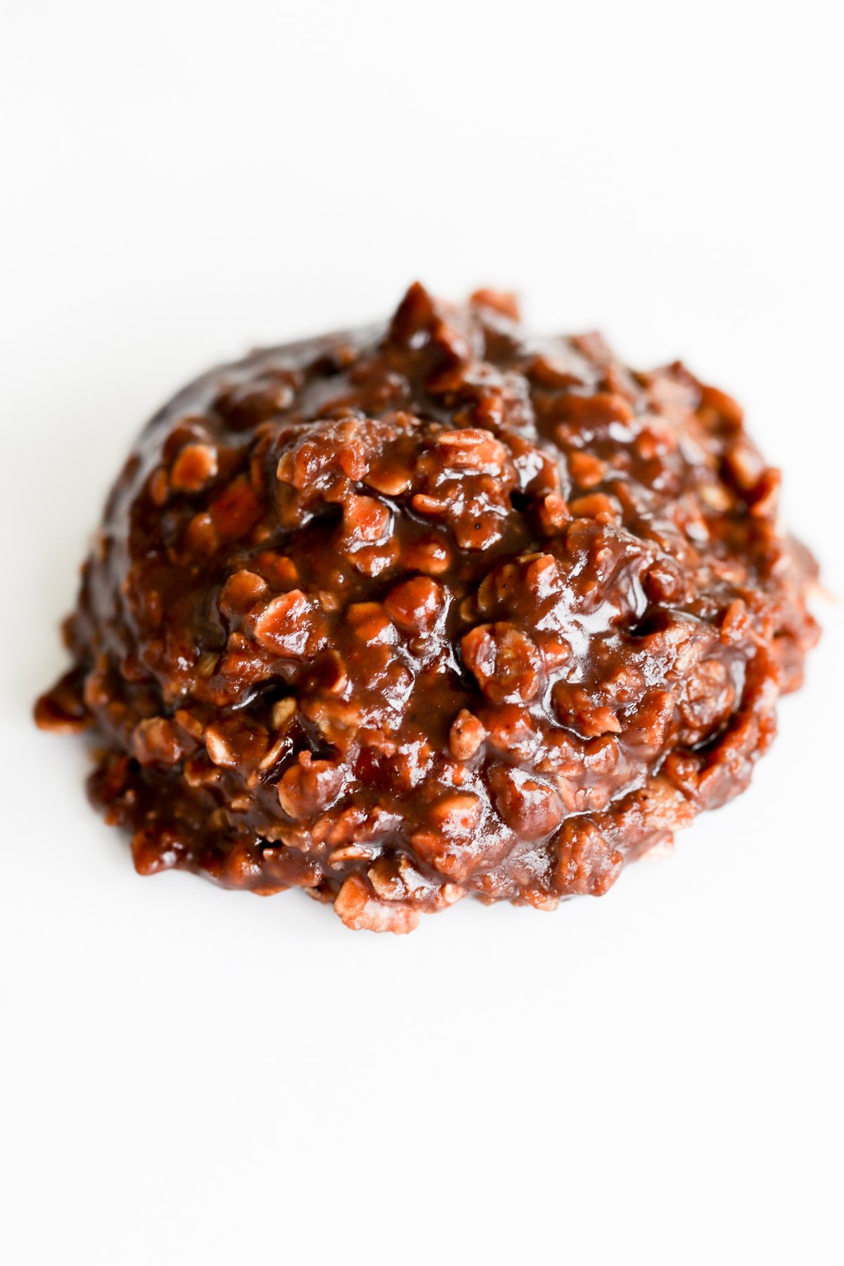 A preacher cookie on a white surface, covered in chocolate.