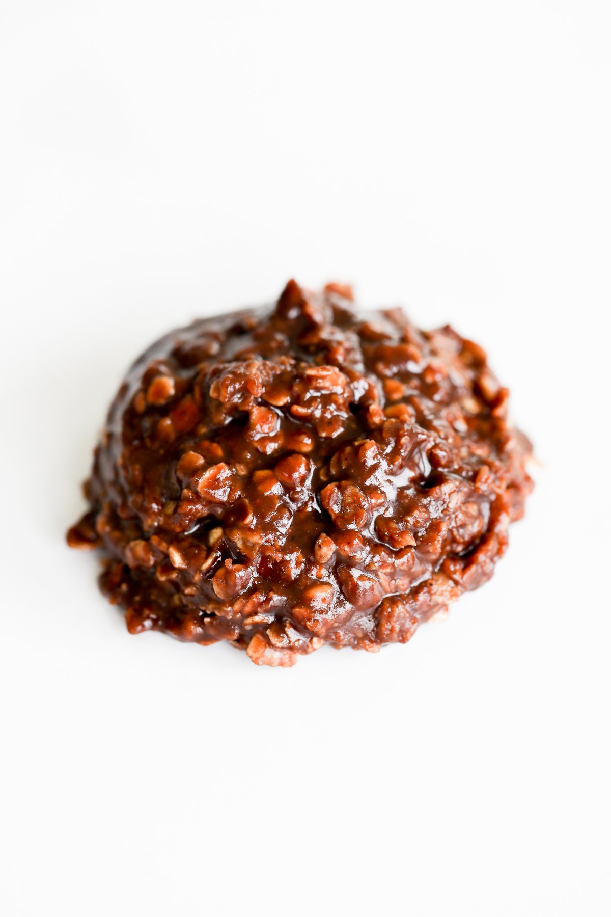 A chocolate covered cookie on a white surface, also known as preacher cookies.