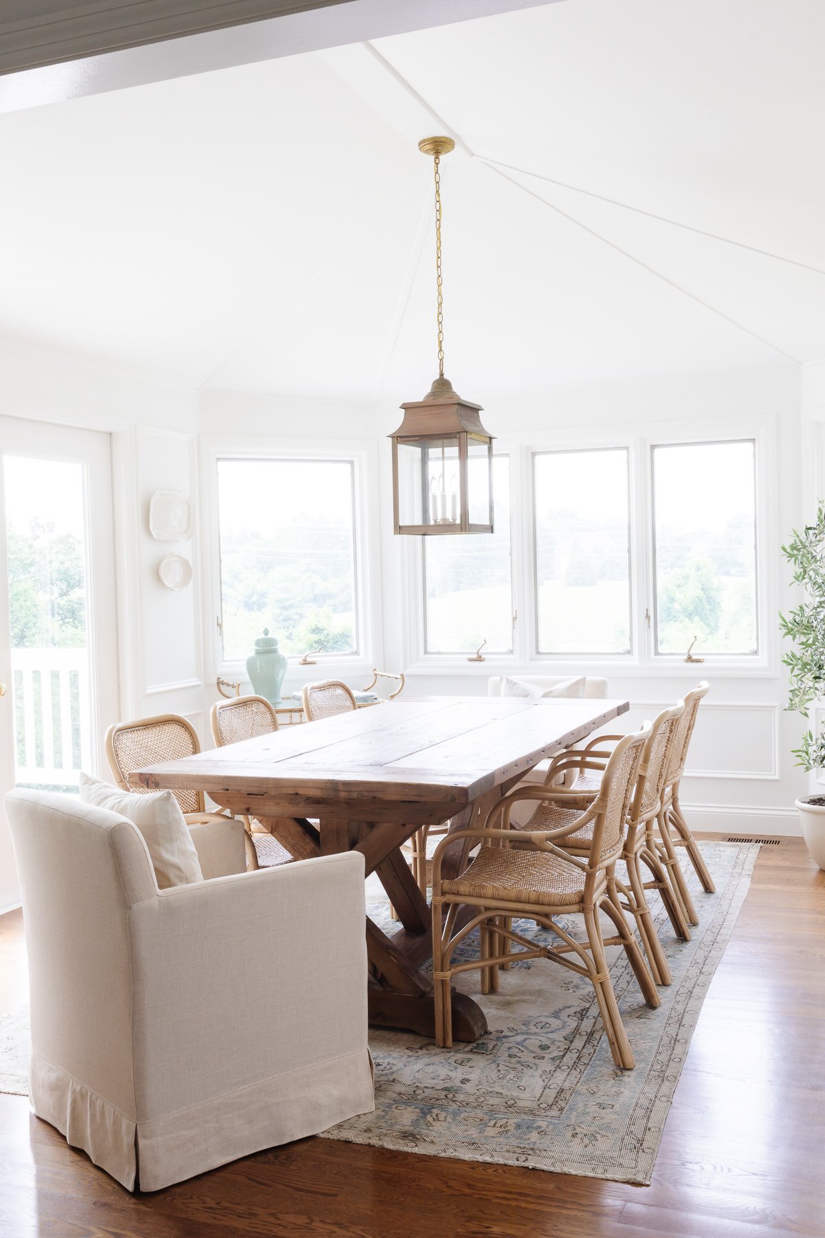 A dining room with a wooden table and chairs, inspired by the RH Look for Less design aesthetic.