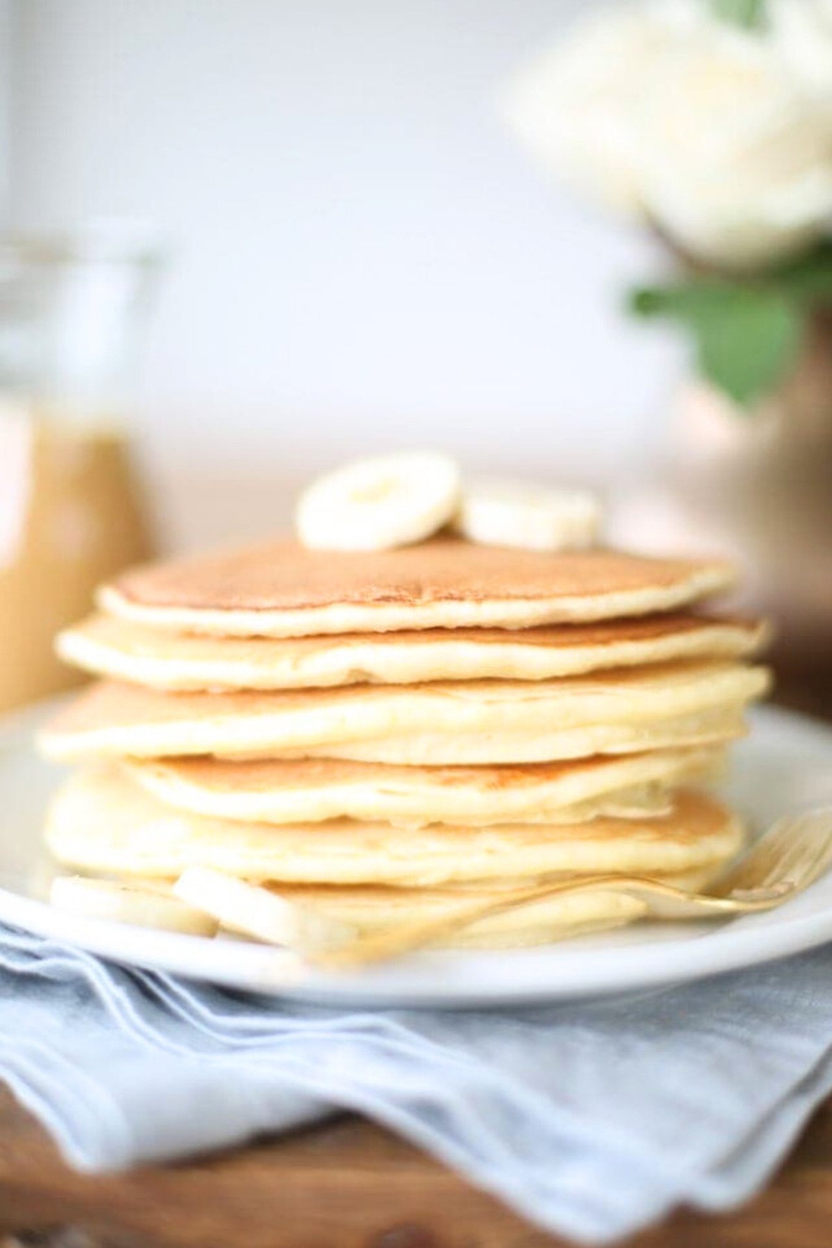 A classic stack of pancakes with syrup on a plate.