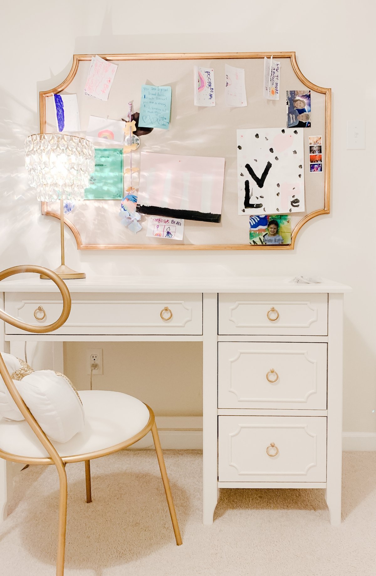A white desk with a gold mirror and chair.
