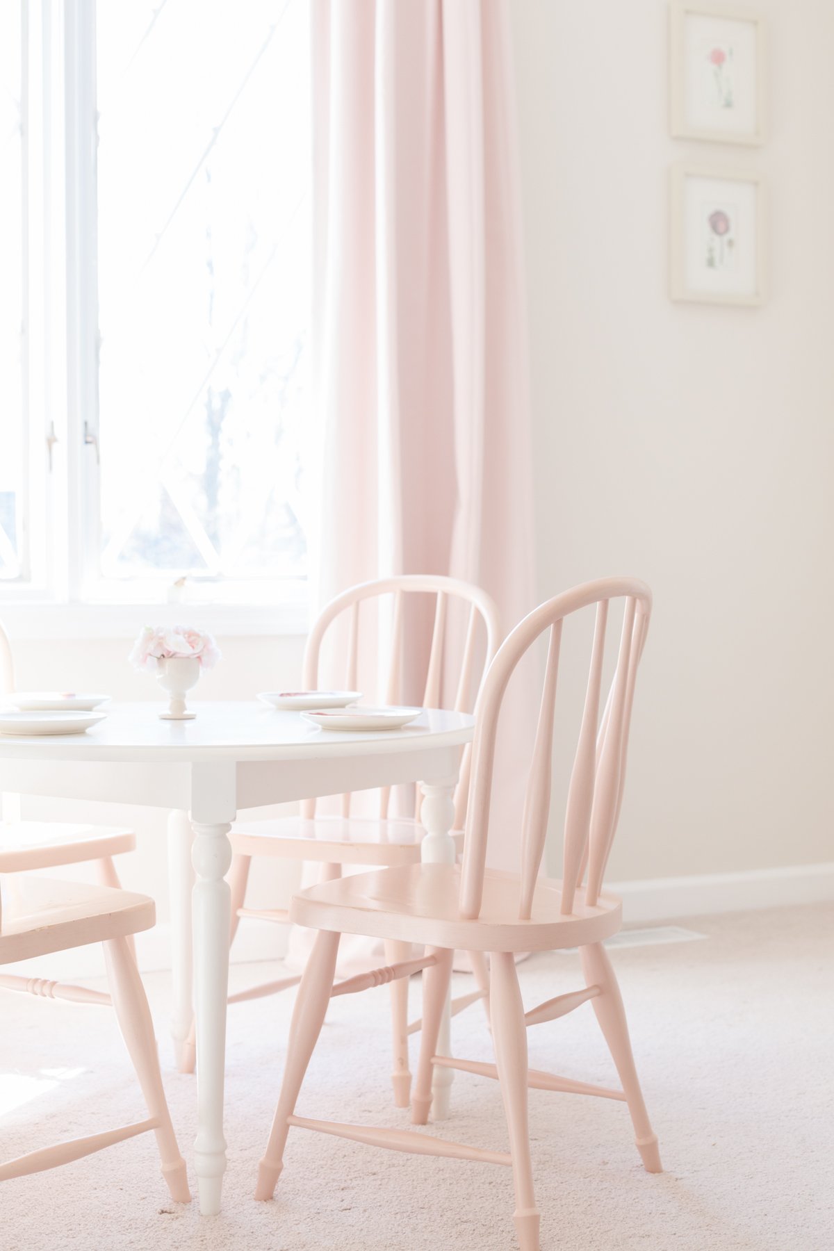 A pink table and chairs in a child's room.
