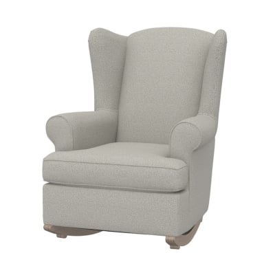 A rocking chair with a beige fabric and wooden legs.