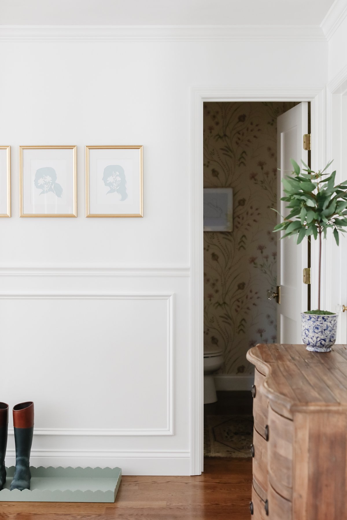 An entryway with white walls and a wooden floor is a must-have on the house cleaning checklist.