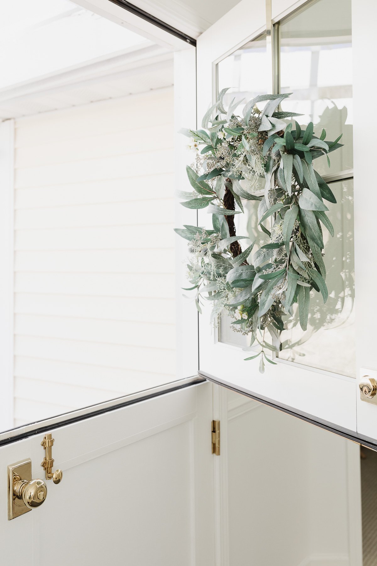 A white door adorned with a spring wreath.