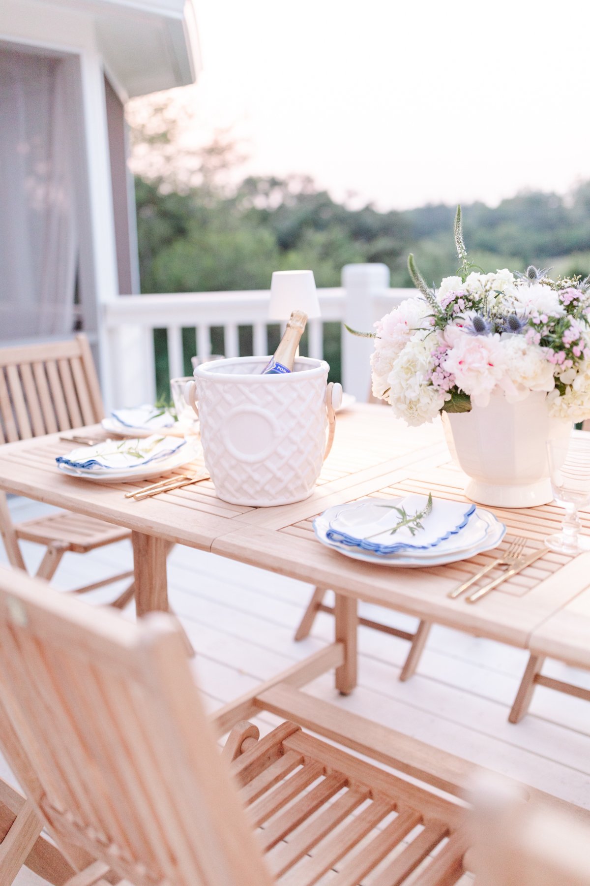 A patio furniture set featuring a wooden table and chairs, adorned with beautiful flowers.