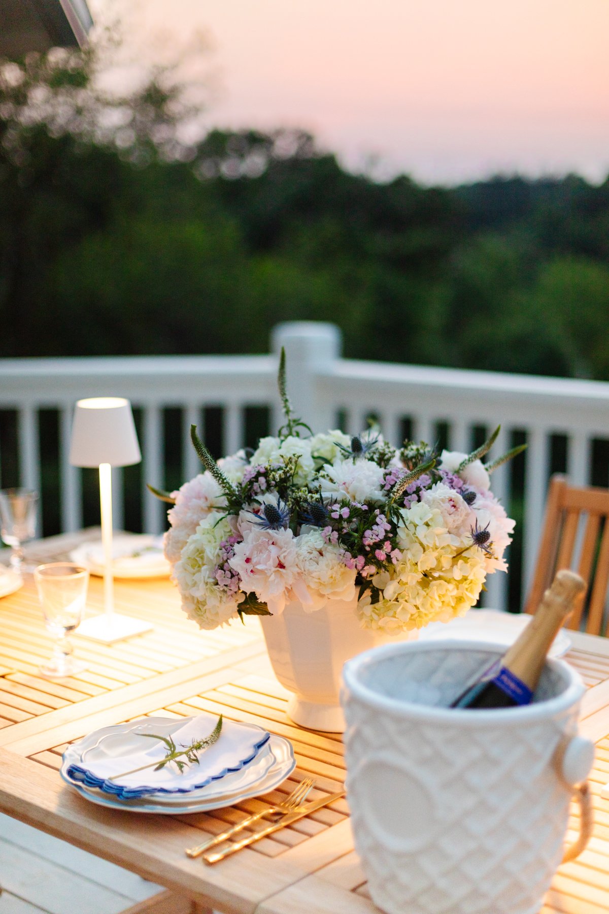 A wooden patio table with flowers on it.