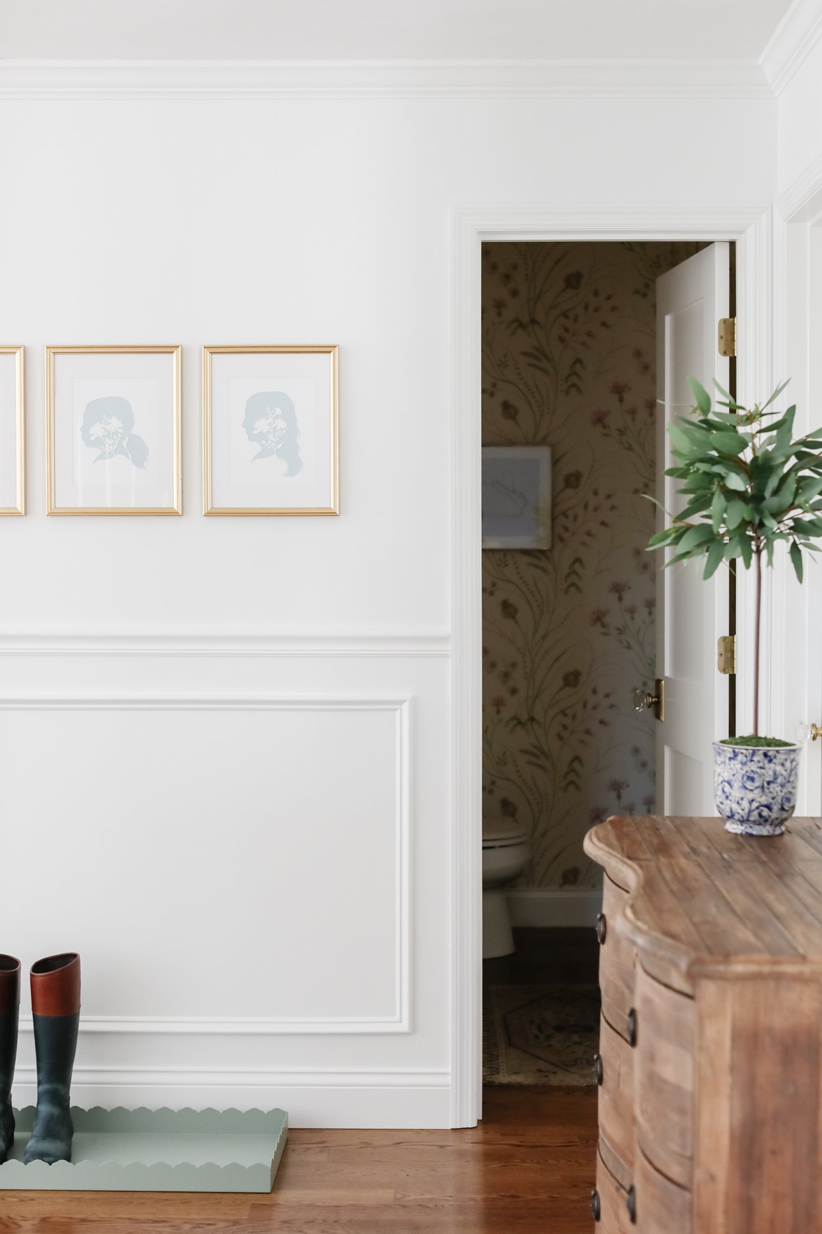 A DIY entryway with white walls and a wooden floor, decorated with creative wall decor ideas.