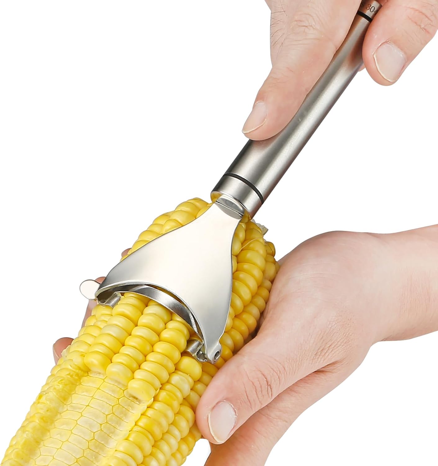 A person skillfully uses a metal corn peeler, one of the essential kitchen gadgets, to effortlessly remove kernels from a cob of corn.