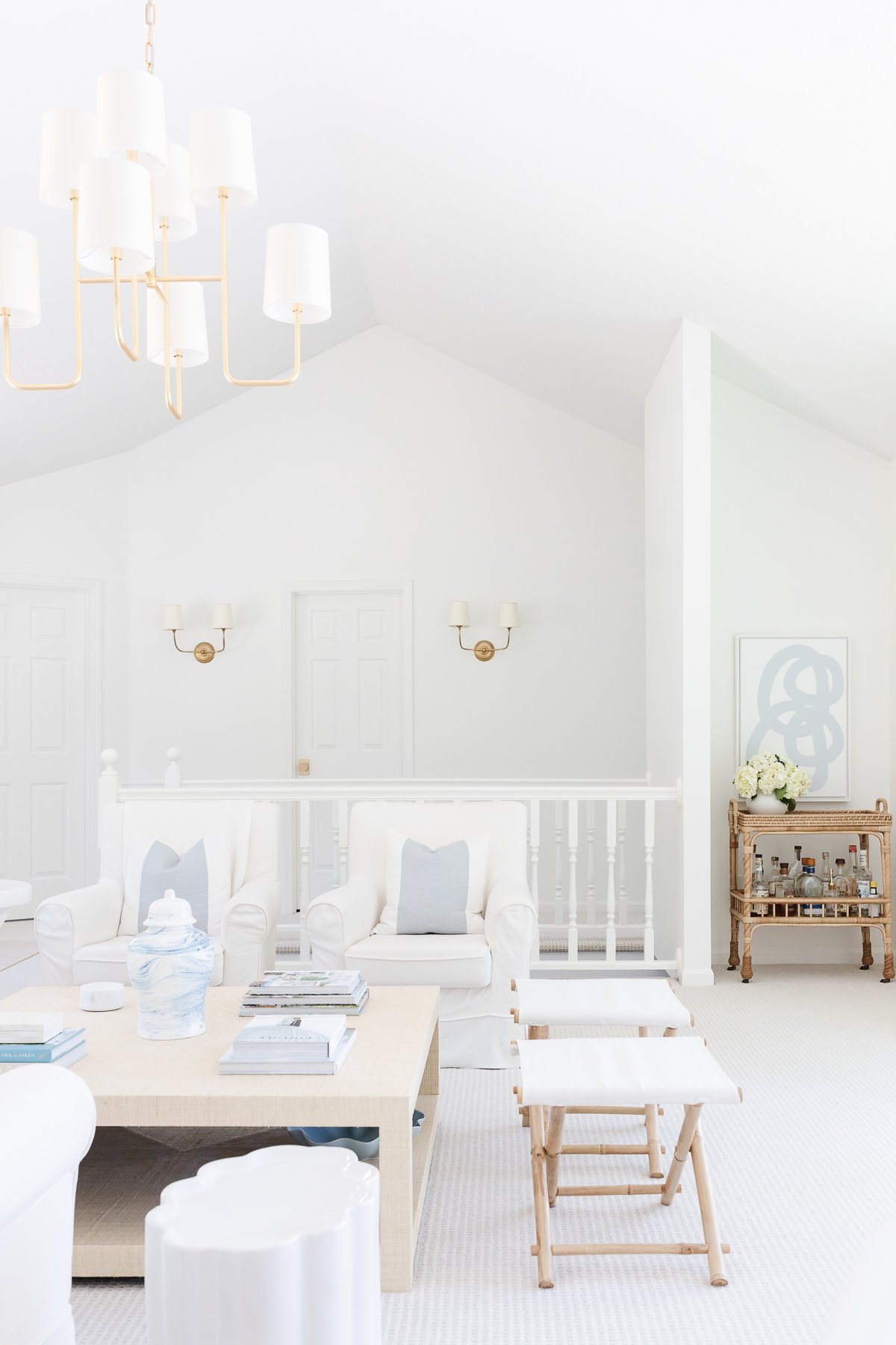 A living room with white furniture and a ceramic chandelier.