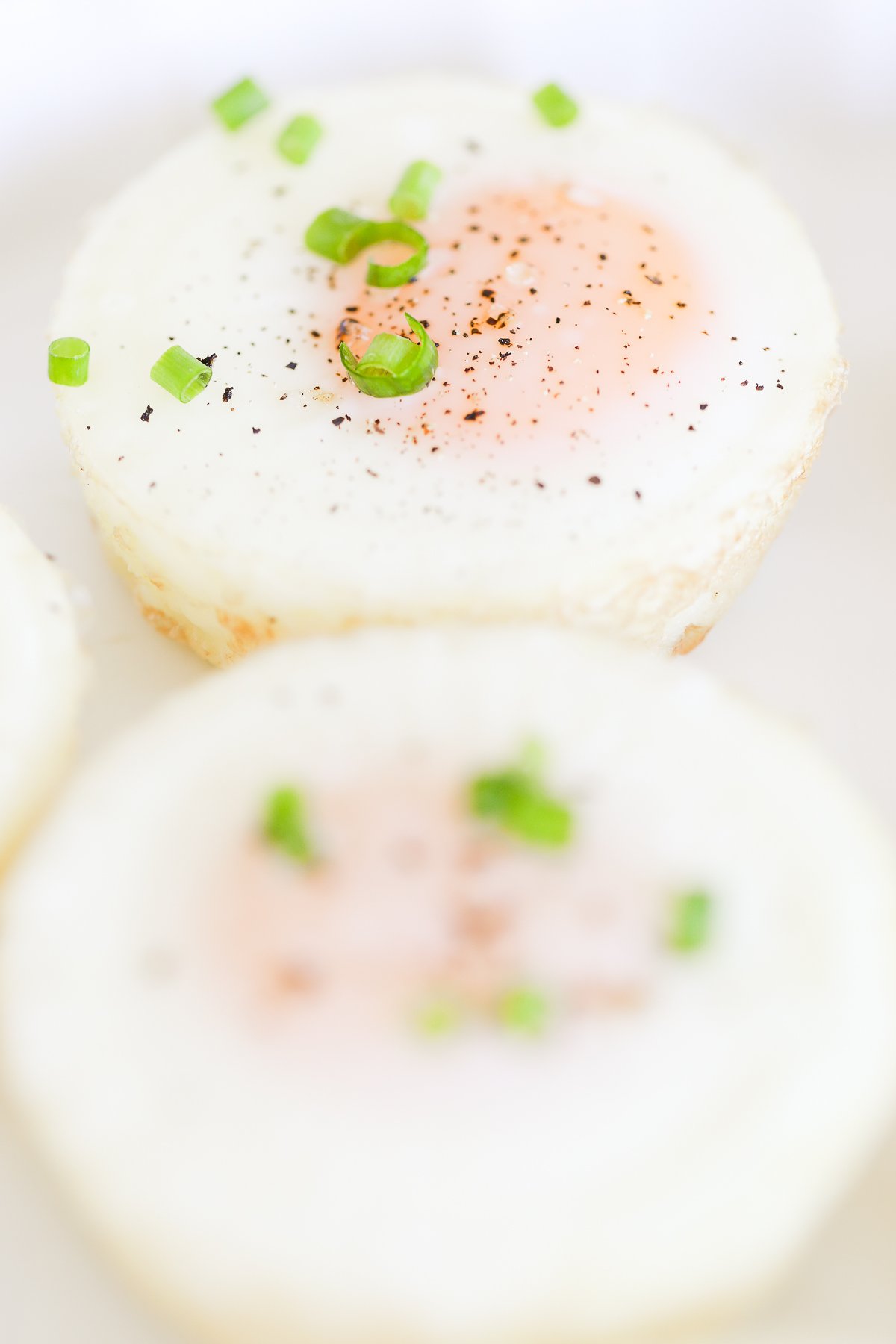 Baked eggs topped with ground pepper and chopped green onions.