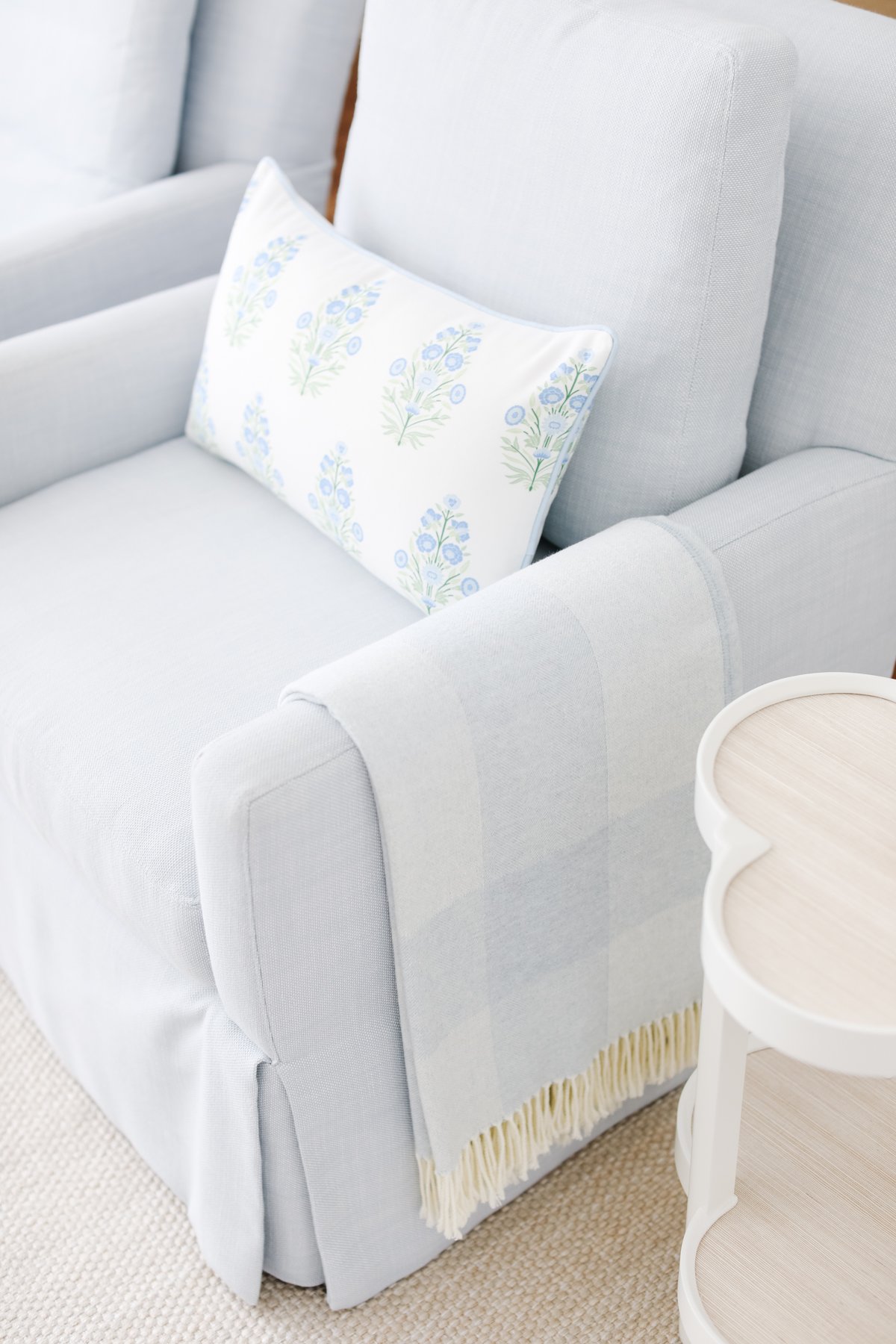 A light blue chair with a white outdoor pillow on it.