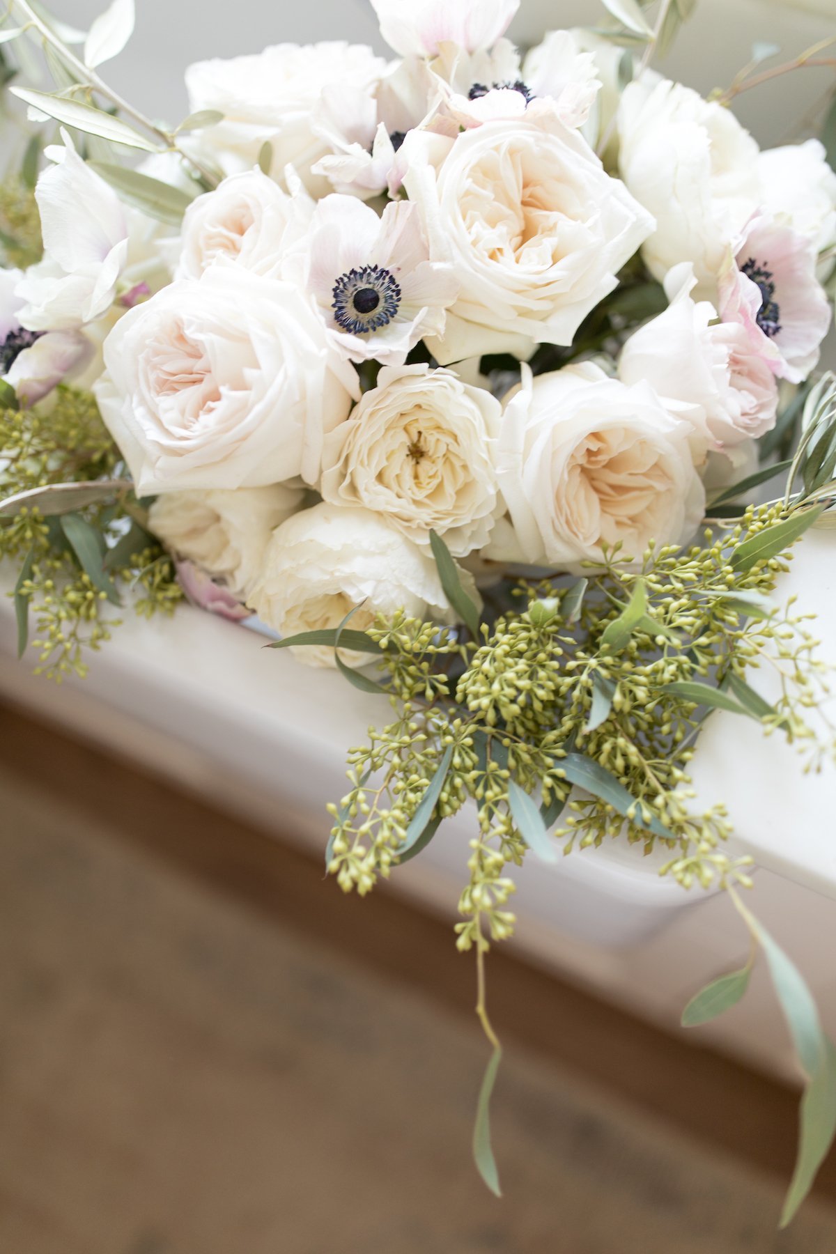 roses and anemones in a white farmhouse sink