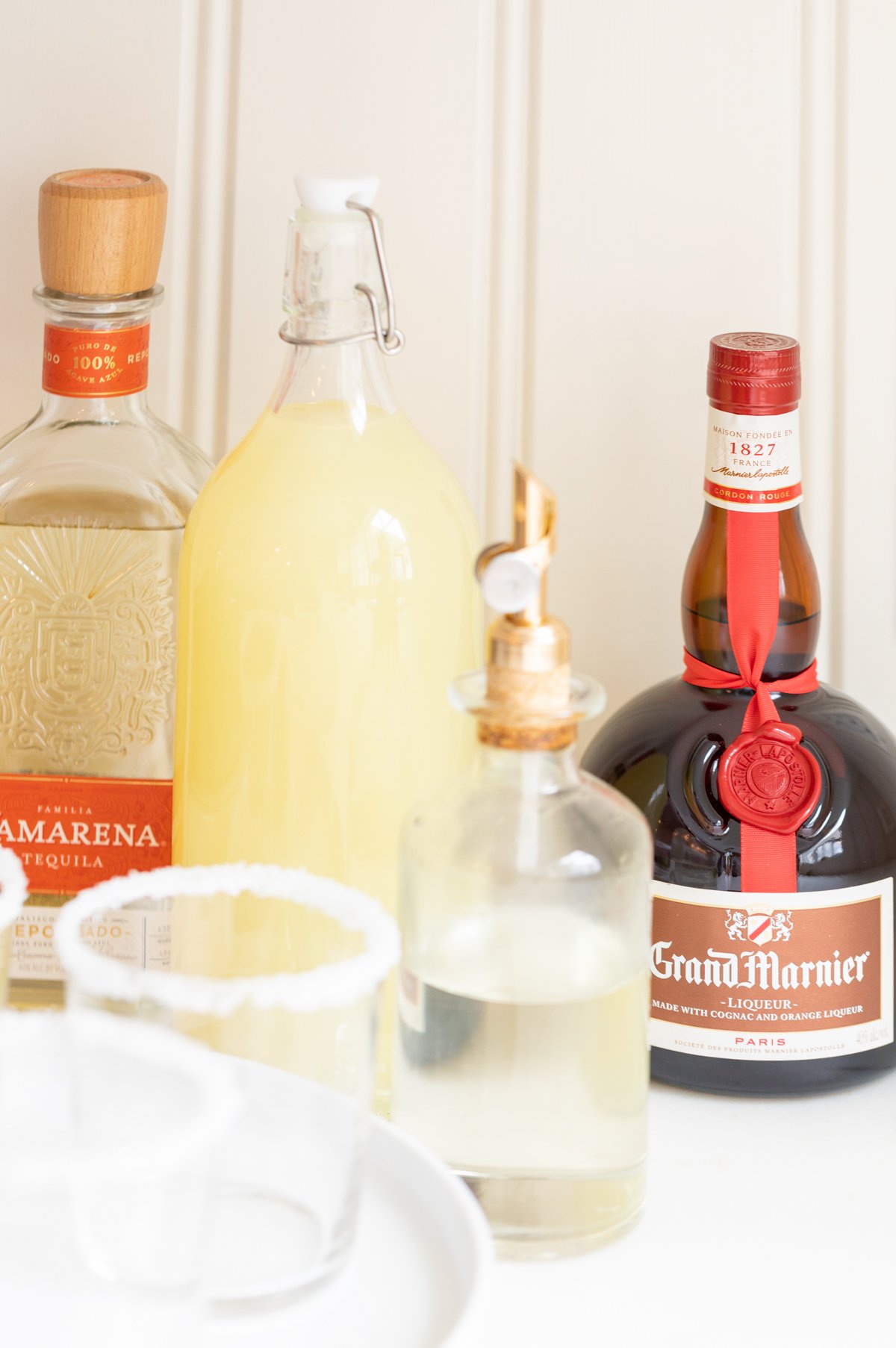 A set up of bottles preparing to make margaritas, with expensive tequila bottle