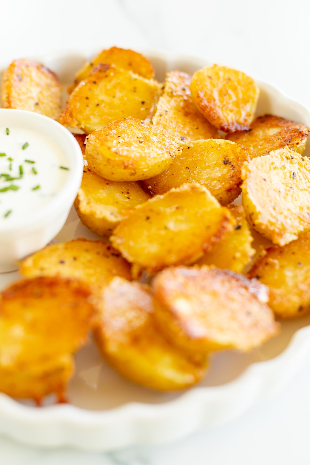 parmesan potatoes on a white platter
