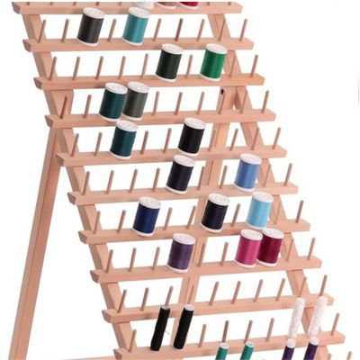 A wooden thread rack, perfect for organizing crafts, holds multiple spools of colorful thread, arranged neatly on its pegs.