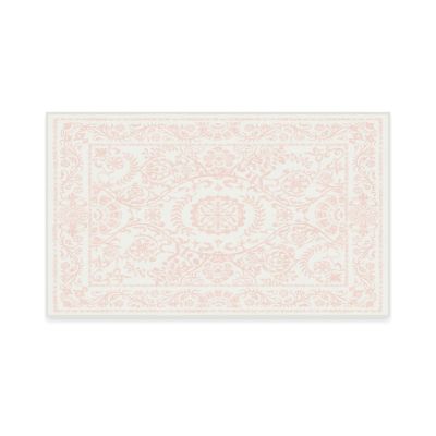 This rectangular rug, inspired by the LoveShackFancy look for less, features a floral and ornate pattern in soft pink on a white background.