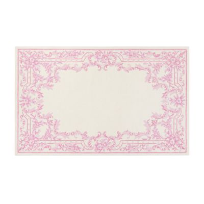 A rectangular rug with a cream center and an ornate pink floral border design, offering the perfect LoveShackFancy look for less.